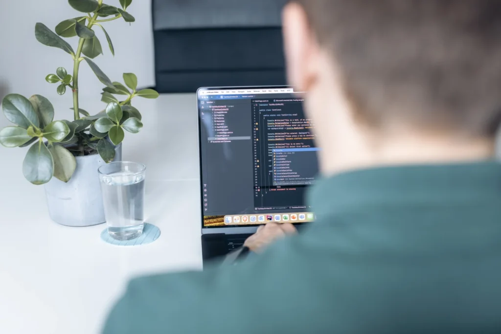 Shoulder view of the screen of the MacBook on which a program in C#/.NET is being developed in the IDE JetBrains Rider.